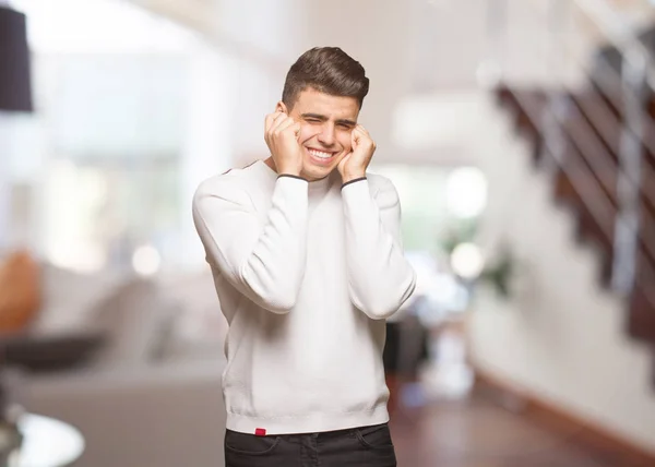 Young authentic man covering ears with hands