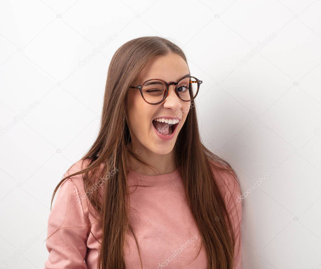 Young cute woman winking, funny, friendly and carefree gesture