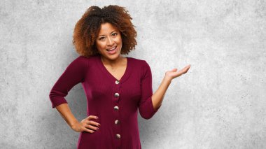 El ile bir şey tutan genç siyah afro kadın