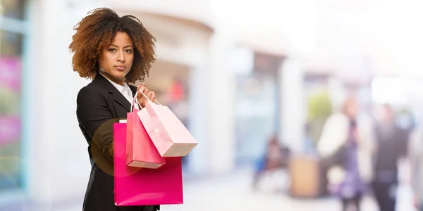 正面を向いて買い物袋を保持している若い黒人女性 — ストック写真