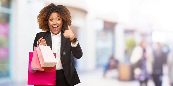 Young Black Woman Holding Shopping Bags Surprised Feels Successful Prosperous — Stock Photo, Image