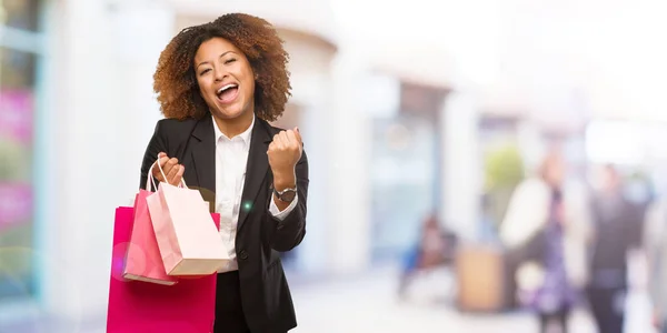 若い黒ショッピング バッグ 驚いて ショックを保持している女性 — ストック写真