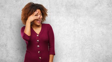 Utandım ve aynı anda gülüyor genç siyah afro kadın