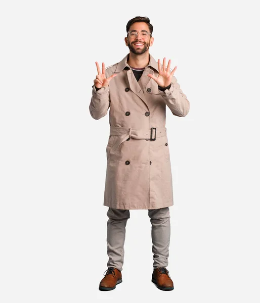 Ung Man Bär Trenchcoat Visar Nummer Åtta — Stockfoto