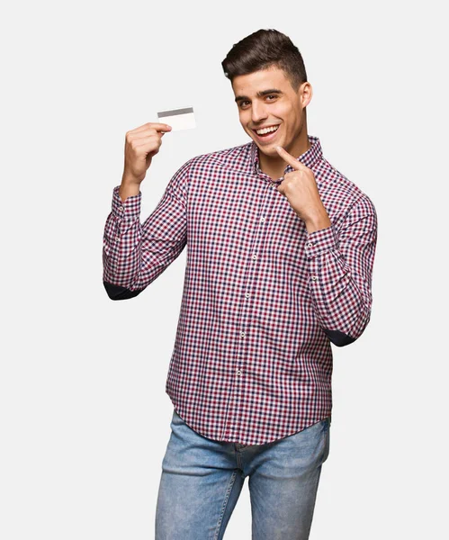 Young Man Holding Credit Card Smiles Pointing Mouth — Stock Photo, Image