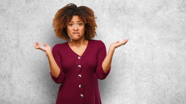 Young black afro woman confused and doubtful