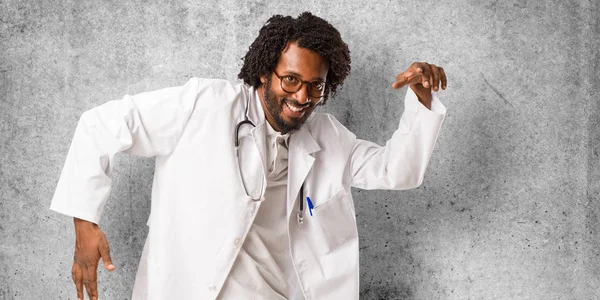 Handsome african american medical doctor Listening to music, dancing and having fun, moving, shouting and expressing happiness, freedom concept