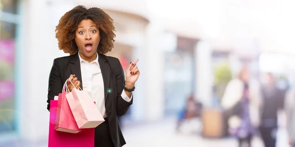 Joven Mujer Negra Sosteniendo Bolsas Compras Apuntando Hacia Lado — Foto de Stock