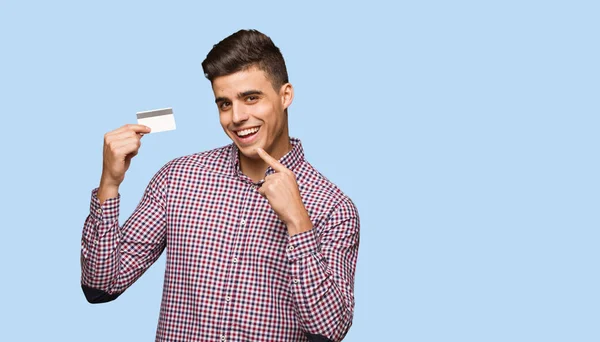 Young Man Holding Credit Card Smiles Pointing Mouth — Stock Photo, Image