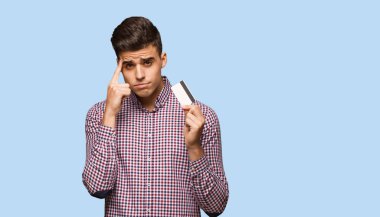 Kredi kartı bir konsantrasyon jest yapıyor tutan genç adam