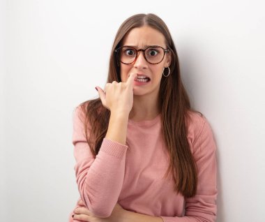 Çivi, sinirli ve tedirgin ısırma genç sevimli kadın