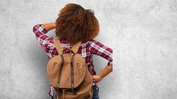 Young traveler black woman from behind thinking about something