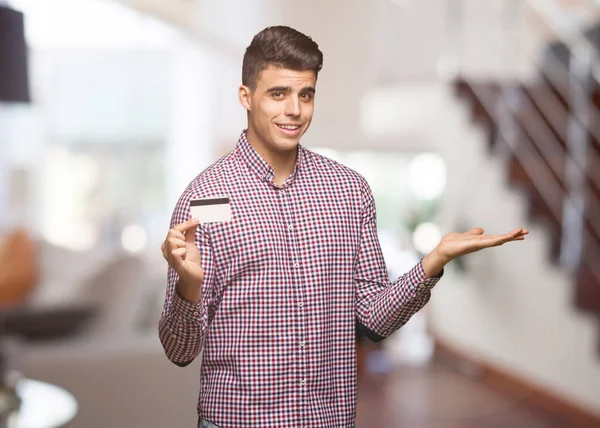 Young Man Holding Credit Card Confused Doubtful — Stock Photo, Image