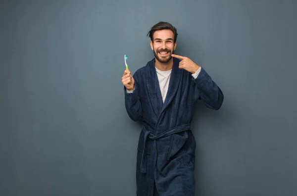 Young man wearing pajama holding a teethbrush — Stock Photo, Image