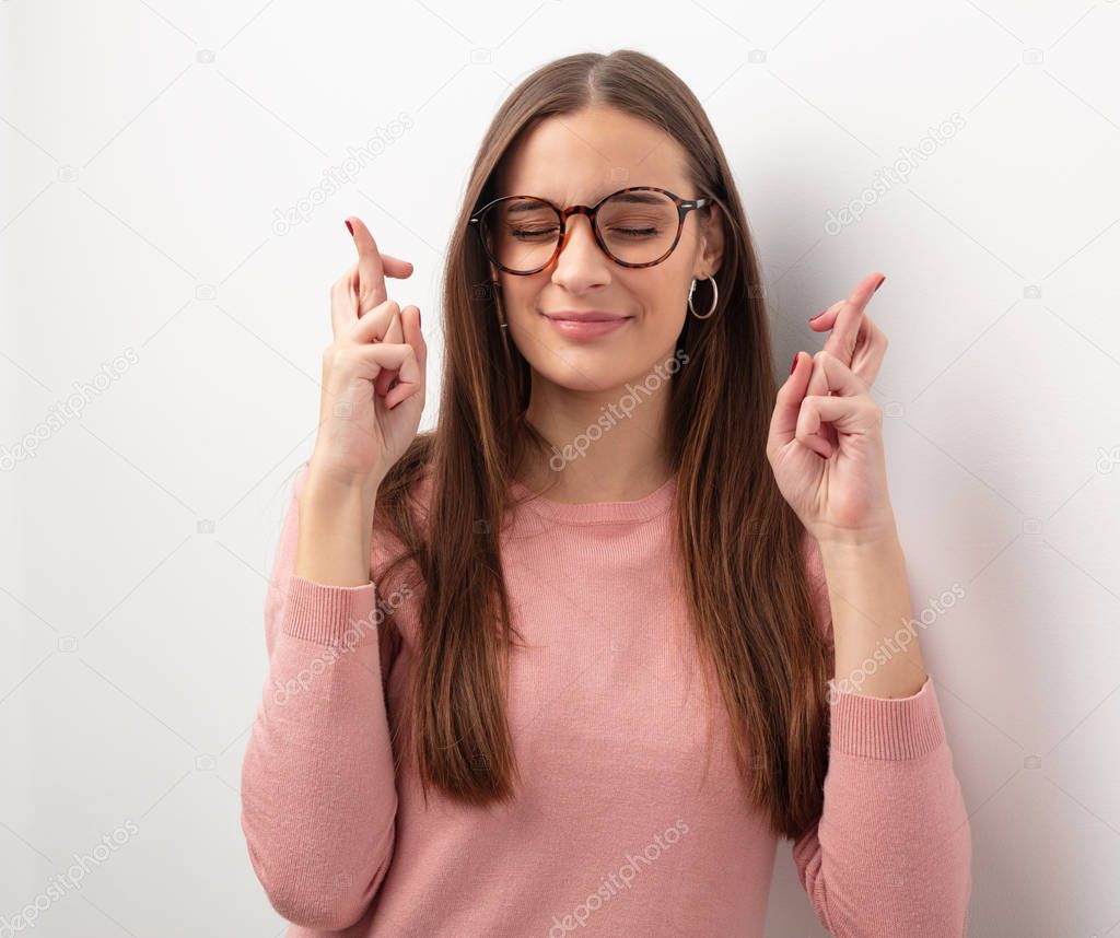 Young cute woman crossing fingers for having luck