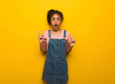 Mavi gözlü genç siyah Afrika kökenli Amerikalı kız bir şey göstermek için yukarıyı şaşırttı