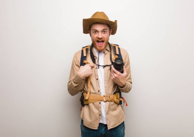 Genç redhead explorer adam şaşırttı, başarılı ve müreffeh hissediyorum. Bir kamera tutarak.
