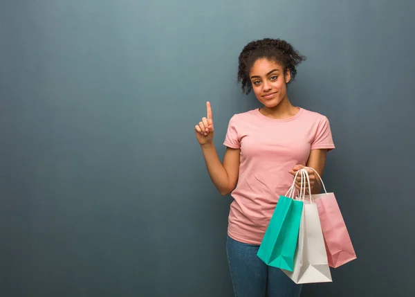 Uma Jovem Negra Mostrar Número Ela Está Segurando Sacos Compras — Fotografia de Stock