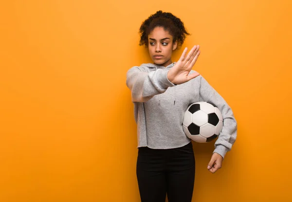 若いフィットネス黒女性前面に手を置きます サッカー ボールを保持しています — ストック写真