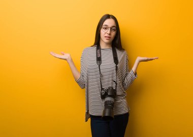 Şüphe ve omuzlarında shrugging genç fotoğrafçı kadın