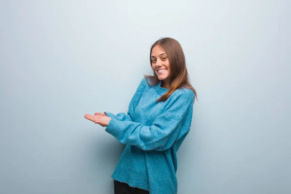 Jovem Mulher Bonita Vestindo Uma Camisola Azul Segurando Algo Com — Fotografia de Stock