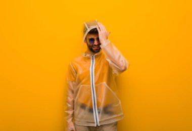 Genç adam bir yağmur ceketli unutkan, bir şey fark