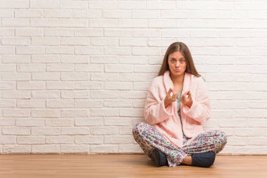 İhtiyacı olan bir jest yapan pijama giyen genç kadın