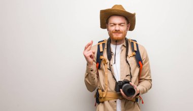 Genç Redhead Explorer adam şans için parmaklar geçiş. Kamera tutma.