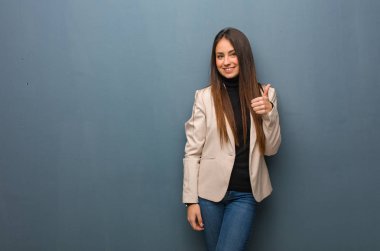 Genç iş kadın gülümseyen ve büyütmek başparmak yukarı