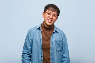 Genç Çinli adam büyük bir gülümseme ile neşeli