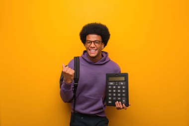 Bir hesap makinesi tutan genç Afrikalı Amerikan öğrenci adam şaşırttı ve şok