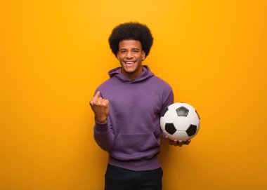 Genç African Amerikan spor adam tutan bir futbol topu şaşırttı ve şok