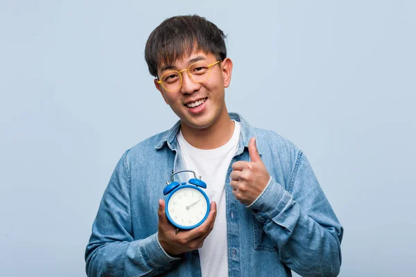 Young Chinese Man Holding Alarm Clock Smiling Raising Thumb — Stock Photo, Image