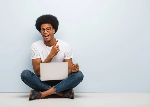 Jonge Zwarte Man Zittend Vloer Met Een Laptop Wijzend Naar — Stockfoto