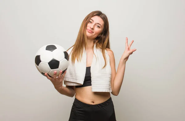 Młoda Fitness Rosyjska Kobieta Robi Gest Zwycięstwa Trzymanie Piłki Nożnej — Zdjęcie stockowe
