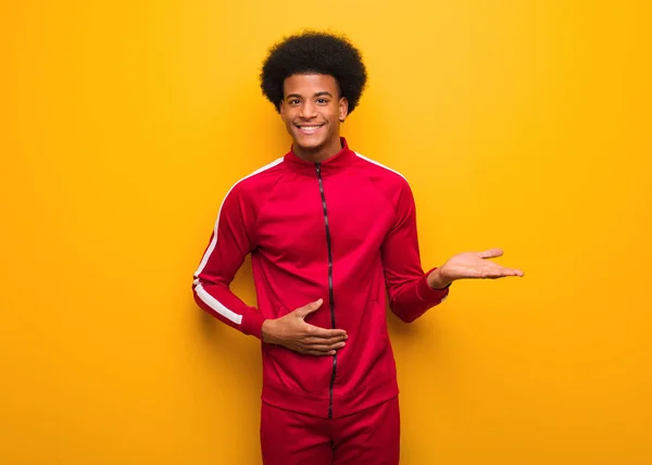 Joven Hombre Negro Deportivo Sobre Una Pared Naranja Sosteniendo Algo — Foto de Stock