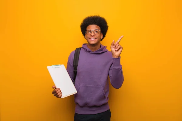 Jovem Estudante Afro Americano Segurando Uma Prancheta Apontando Para Lado — Fotografia de Stock