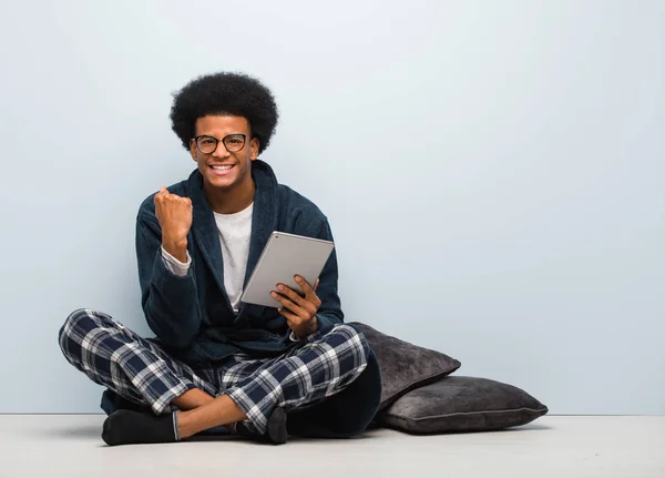 Jovem Negro Sentado Sua Casa Segurando Seu Tablet Surpreso Chocado — Fotografia de Stock