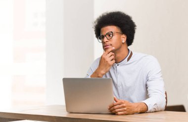 Genç siyah adam kullanarak onun laptop şüphe ve karıştı