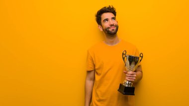 Hedefleri ve amaçları elde rüya bir kupa tutan genç adam