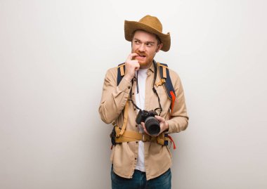 Genç Redhead Explorer adam bir kopya alanı bakarak bir şey hakkında düşünme rahat. Kamera tutma.