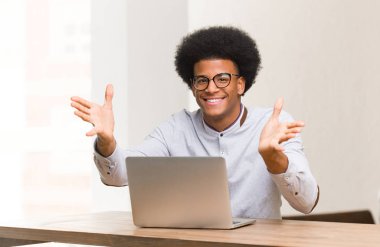 Genç siyah adam kullanarak onun laptop çok mutlu vererek bir sarılmak için bu ön