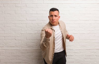 Genç Latin adam gösteren yumruk için ön, öfkeli ifade