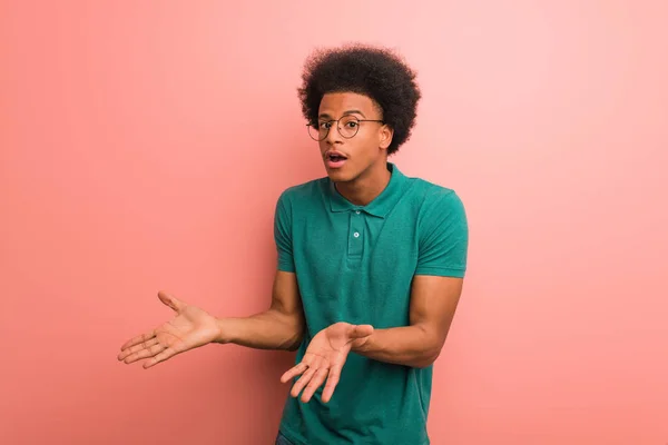 年轻的非洲裔美国人在粉红色的墙壁困惑和怀疑 — 图库照片