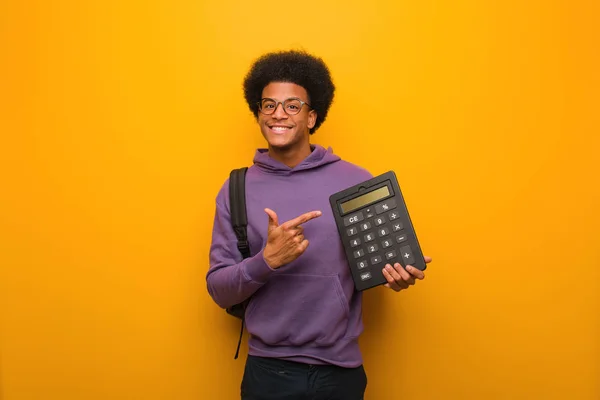 Jovem Estudante Afro Americano Segurando Uma Calculadora Apontando Para Lado — Fotografia de Stock