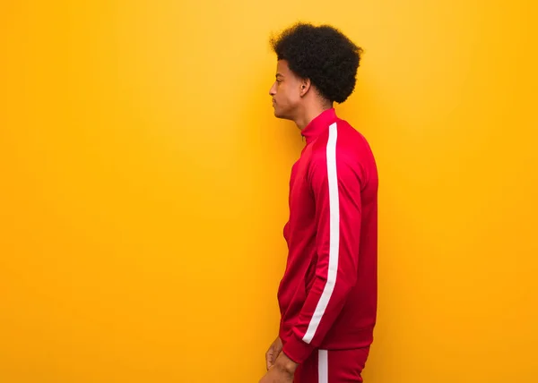 Genç Spor Siyah Adam Üzerinde Bir Turuncu Duvar Üzerinde Yan — Stok fotoğraf