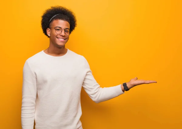 Giovane Uomo Afroamericano Sopra Muro Arancione Che Tiene Qualcosa Con — Foto Stock
