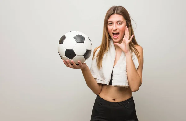 年轻的健身俄罗斯女子向前面喊着一些快乐的东西 拿着足球 — 图库照片