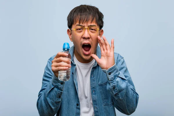 Joven Chino Sosteniendo Una Botella Agua Gritando Algo Feliz Frente — Foto de Stock