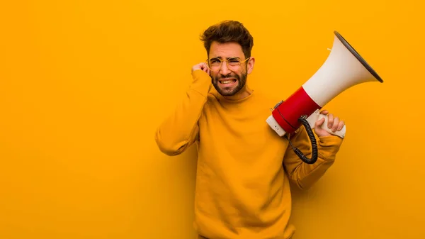 Ung Man Som Innehar Megafon Som Täcker Öronen Med Händer — Stockfoto